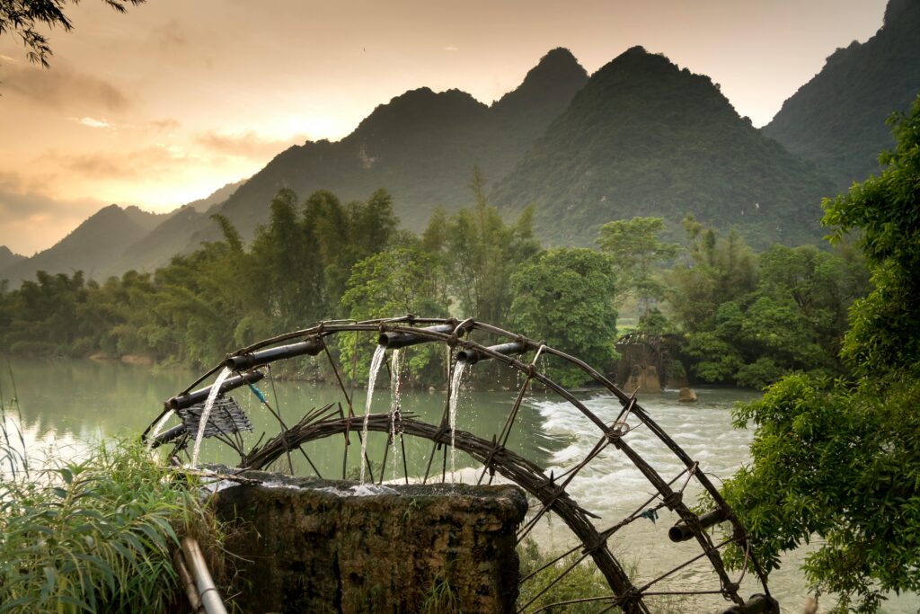 Traditional bamboo water wheel on a river used for irrigation in organic farming.