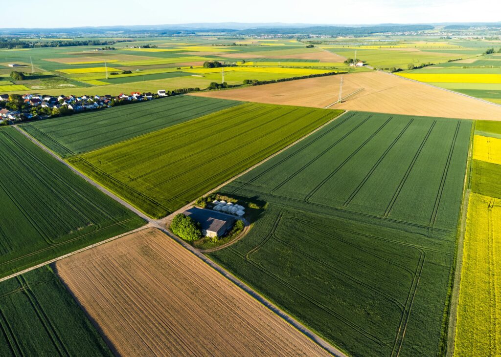 smart farming
Aerial view of farmland with a tractor working on neatly divided green and brown agricultural fields.
