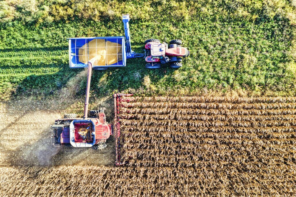 a farming tech image of a tractor working on cultivated soil.